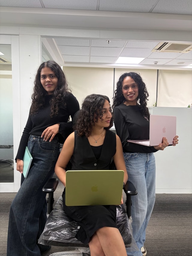 Three team members with their laptops in the office